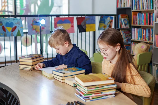 Kisiskolások Együtt Olvasnak Könyveket Miközben Könyvtárban Ülnek Asztalnál Fiú Lány — Stock Fotó