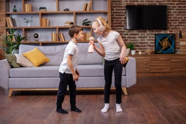 Karaoke 'de iki çocuk şarkı söylüyor. Küçük oğlan ve kız eğleniyor. Kavram çocukluk, vokal, müzik, şarkı söyleme, arkadaşlık..