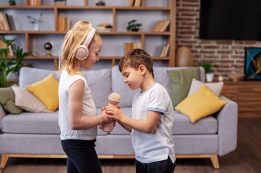 Karaoke 'de iki çocuk şarkı söylüyor. Küçük oğlan ve kız eğleniyor. Kavram çocukluk, vokal, müzik, şarkı söyleme, arkadaşlık..