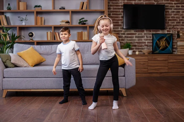 Two children sing song in karaoke. Little boy and girl having fun. Concept is childhood, vocal, music, singing, friendship.