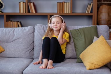 Mutlu çocuk müzik dinler ya da sesli kitap okur. Kulaklık takan küçük bir okul çocuğu. Müzik günümü gün ediyor.