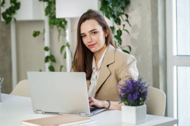 Kadın modern ofiste dizüstü bilgisayarda çalışıyor. Muhasebe analizi yapmak gayrimenkul yatırım verileri, mali ve vergi sistemleri kavramı