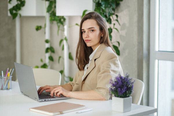 Женщина работает за ноутбуком в современном офисе. Данные по инвестициям в недвижимость, концепция финансовых и налоговых систем