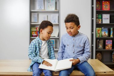 İki Afrikalı Amerikalı çocuk kitap okuyor, okulda okuyor ve eğleniyorlar. Okula dönelim. Arkadaşlık, aile, çocukluk ve öğrenim kavramı.