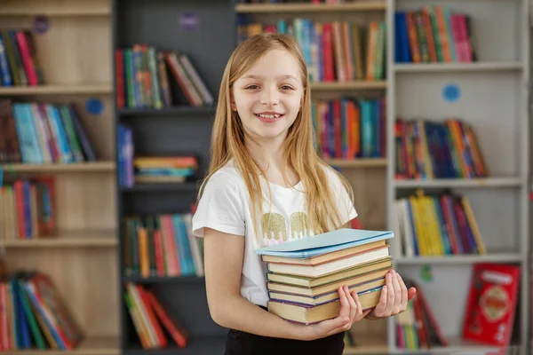 孩子在书店买书是为了学习或读书 女孩在学校图书馆选书 日常阅读的益处 — 图库照片