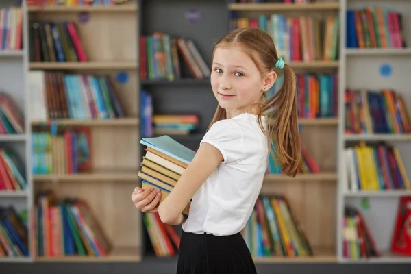 Child buys books in bookstore for learning or reading. Girl choosing book in school library. Benefits of everyday reading.