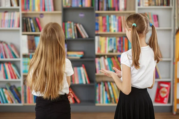 两个女学生在学校图书馆里选书 书店架子上的书 聪明的女孩选择阅读文学 — 图库照片