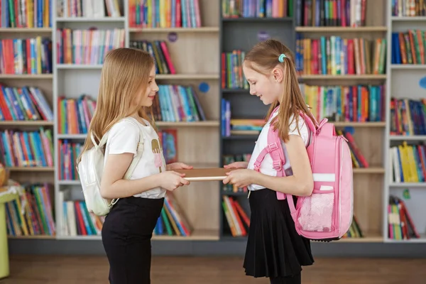 Дві Дівчини Рюкзаками Зустрічаються Обмінюються Книжками Шкільній Бібліотеці Повернутися Школи — стокове фото