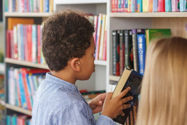 Twee Klasgenoten Zoeken Boeken Buurt Van Boekenplanken Lezen Samen Schoolbibliotheek — Stockfoto