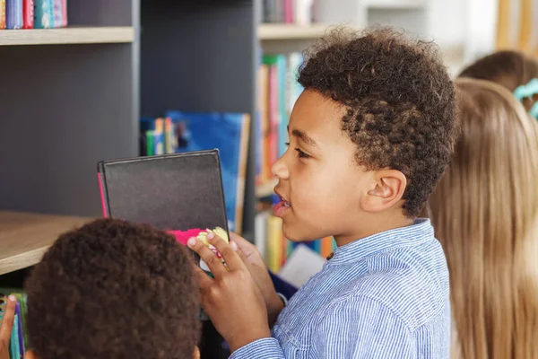 Többnemzetiségű Gyerekek Könyveket Keresnek Könyvespolcok Közelében Együtt Olvasnak Iskolai Könyvtárban — Stock Fotó