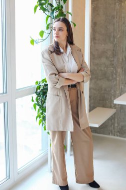 Yeşil ofisteki iş kadını pencereden dışarı bakıyor. İş konsepti. Bitkilerle dolu ofis.