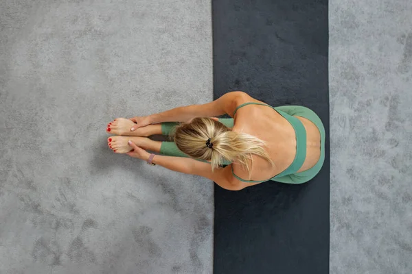 女人在工作室的垫子上做瑜伽练习 运动和健康的生活方式概念 顶部视图 复制空间 — 图库照片