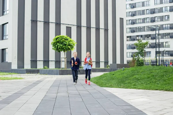 stock image Boy and girl with backpack behind back. Back to school. Children go to school for study. Beginning of school lessons.