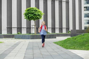 Okul derslerine başlıyorum. Mutlu liseli kız dışarıda sırt çantasıyla koşuyor ve gülümsüyor. Okula dönelim. Çocukluk kavramı, eğitim