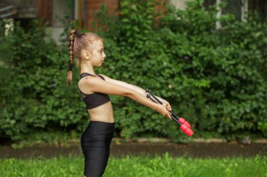 Küçük sportif kız dışarıda jimnastik topuzuyla egzersiz yapıyor. Ritmik jimnastik. Sağlık hizmetleri kavramı