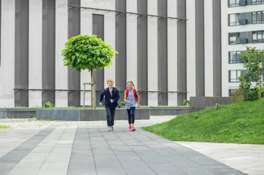 Sırt çantalı kız ve erkek. Okula dönelim. Çocuklar okumak için okula koşar. Okul derslerinin başlangıcı..