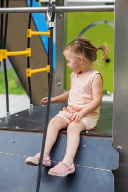 Küçük kız çocuk parkında eğleniyor. Anaokulu, bebek gelişimi ve ilk yıllar kavramı