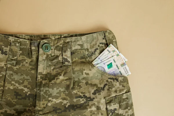 Ukrainian hryvnia in uniform pocket. Military pay concept. Money of Ukraine. Military uniform
