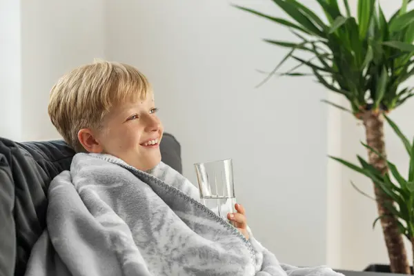 高熱と喉の痛みを伴う病気の19歳の少年は ソファーで自宅に座って悪気を感じます 季節的なコールド — ストック写真