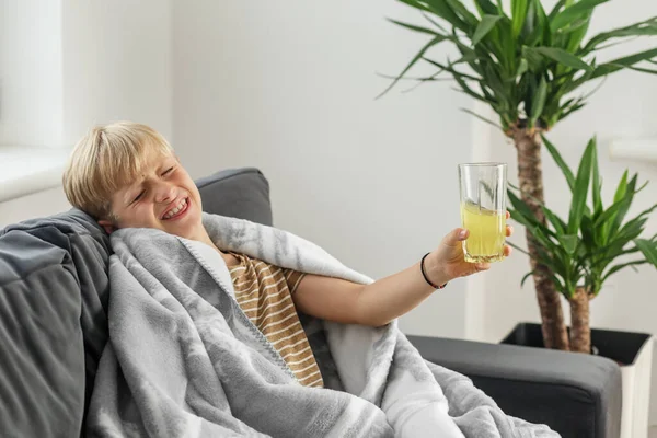 高熱と喉の痛みを伴う病気の19歳の少年は ソファーで自宅に座って悪気を感じます 季節的なコールド — ストック写真