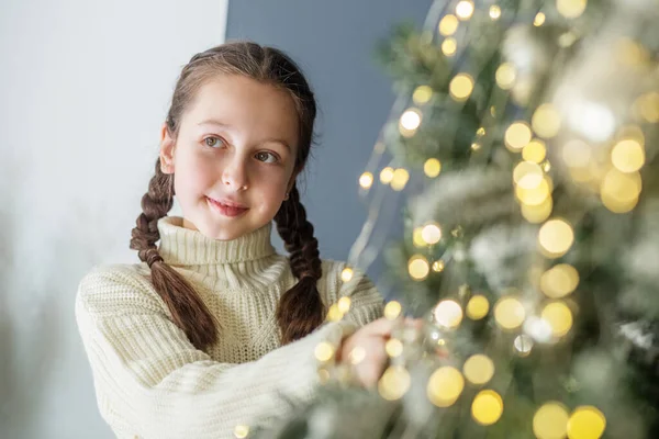 Mutlu Noeller ve mutlu tatiller! Çocuk reşit olmayan kız içeride Noel ağacı süslüyor..