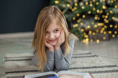 Mutlu Noeller ve mutlu tatiller. Çocuk odada kitap okuyor. Yeni Yıl, Mutlu Noeller, tatil, tatil, kış, çocukluk. Konforlu ev.