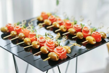 Etkinlikte yemek yiyorum. Atıştırmalıklı plastik bardaklar, zeytinli somon. Atıştırmalık ve aperatiflerle servis masası..