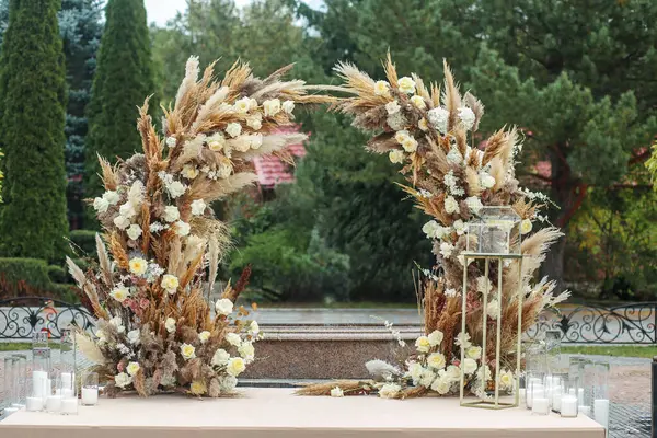 Wedding event. Decor of the wedding ceremony area with fresh flowers and pampas grass