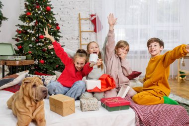 Çocuklar evde sihirli Noel hediyelerini açıyor. Boks Günü.