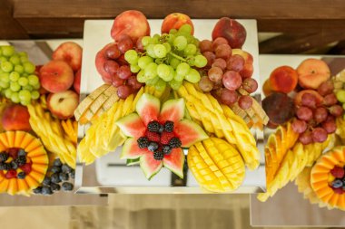 Etkinlikte yemek yiyorum. Canlı ve sanatsal olarak düzenlenmiş çeşitli taze meyveler içeren meyve tabakları.