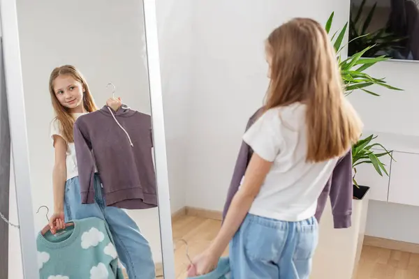 스웨터를 들고있는 거울을보고있는 그녀의 방에서 로열티 프리 스톡 이미지