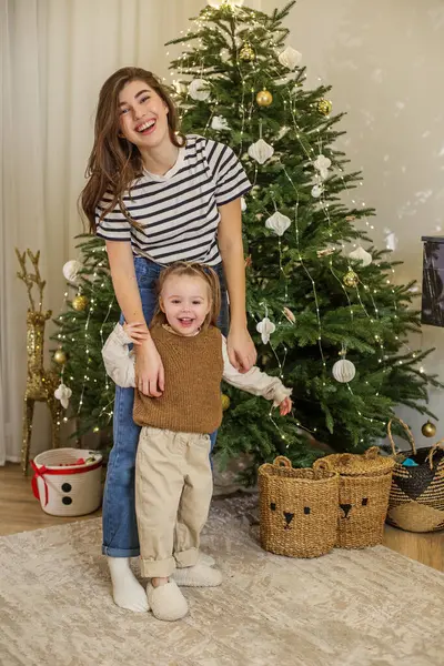 Küçük çocuk, Noel boyunca Noel atmosferinin tadını çıkararak, süslü ağaçların yanında gülümsüyor. Aile bir araya gelir, Noel ruhunu ve neşesini gösterir..