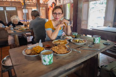 Endonezya 'da kırsal bir restoranda yemek yiyen bir kadın. Geleneksel Cava yemekleri servis ediyorum..