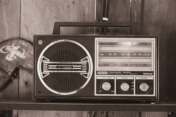Eski bir 3 bantlı transistör radyo ahşap bir dolabın üstünde duruyor..