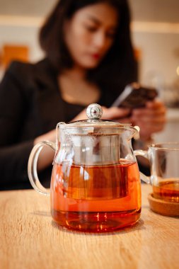 Çay ve fincanlarla dolu cam bir çaydanlık. Siyah takım elbiseli güzel bir kadının bulanık bir geçmişi var..