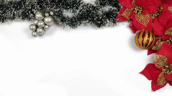 Kırmızı şeffaf Noel kurdeleli çam dalları ve gümüş üzümlerden oluşan bir Noel süsü. Beyaz bir arkaplanda fotoğraflandı.