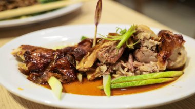 Lezzetli sosla servis edilen ağız sulandıran kızarmış ördek yemeği ve zarif beyaz bir tabakta taze sebze. Kıtır kıtır, altın gibi mükemmel pişirilmiş, yemek çok lezzetli..