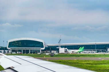 Terminal 3 building at Soekarno-Hatta Airport, Jakarta, seen from inside the cabin of a plane about to take off. clipart