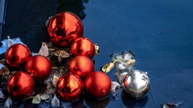 A pond with clear water, which is decorated with Christmas ornaments in the form of Christmas balls. clipart