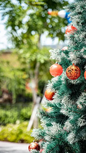 Ağaç dalları Noel topları şeklinde birkaç Noel süsüyle asılıdır..
