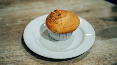 Beyaz tabakta altın-kahverengi bir çöreğin yakın plan çekimi. Dokusunu ve davetkar görünümünü gözler önüne seriyor. Yemek blogları veya yemek siteleri için ideal..