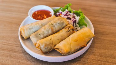 Lumpia, which is a typical food from the city of Semarang, Central Java. It consists of bamboo shoots with dried shrimp, wrapped in spring roll skin and then fried. Served with chili sauce and salad. clipart