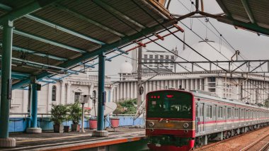 Jakarta banliyö hattı Juanda İstasyonu 'na giriyor, Jakarta. Arkasında, Istiqlal Camii 'ni görebilirsiniz..