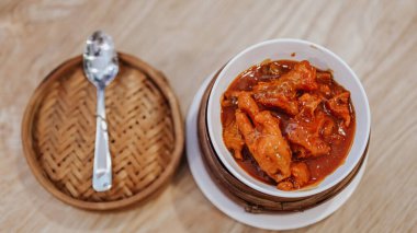 Baharatlı baharatlarla pişirilmiş tavuk ayağı küçük bir kasede servis edilir..