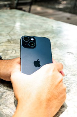 El ele tutuşan iPhone 15.