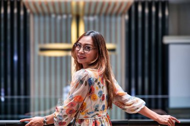 Omuz hizasında sarı saçlı güzel bir kadın kilisedeydi. Duvarda bir haç var..