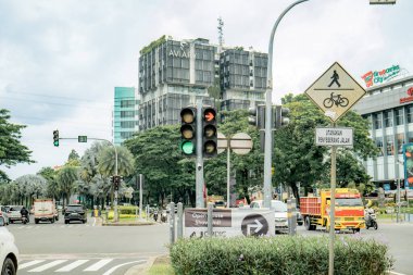 Jakarta 'da bir kavşak, sağa dönenler için yeşil, düz gidenler için kırmızı ışık yanıyor. Arka planda belediye binası var..