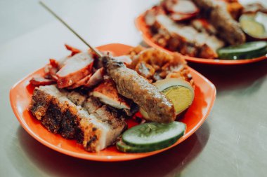 Bir Çin restoranının menüsü domuz eti, domuz eti siu, sosis, domuz kulağı, deri, yumurta ve domuz satayından oluşur. Salatalık dilimleriyle.