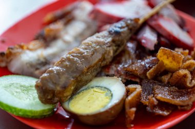 Bir Çin restoranının menüsü domuz eti, domuz eti siu, sosis, domuz kulağı, deri, yumurta ve domuz satayından oluşur. Salatalık dilimleriyle.