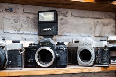Nikon EM ve Asahi Pentax gibi ünlü kamera markalarını gösteren eski moda bir dükkan. Hala analog teknoloji kullanılıyor.